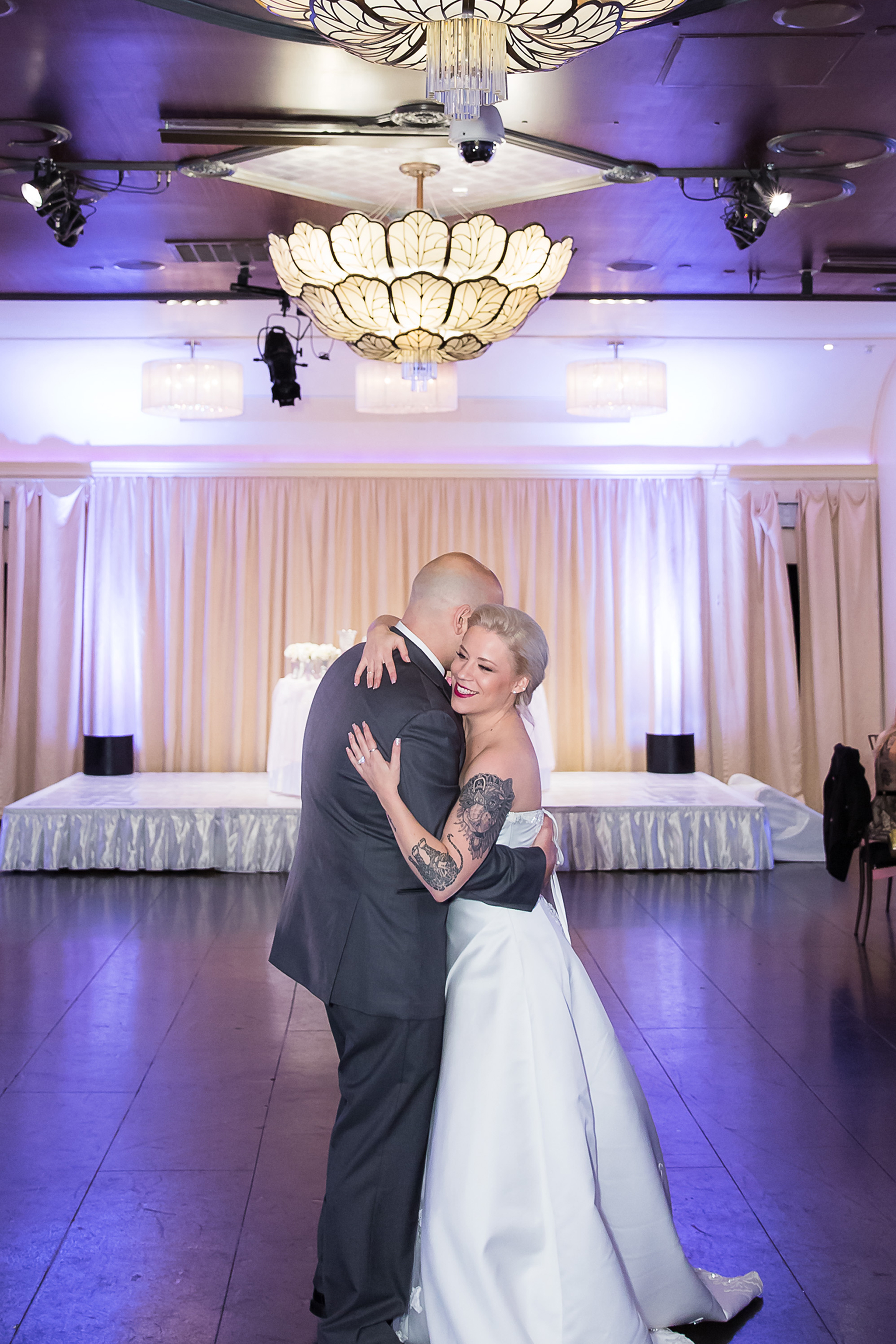 first dance with bride adn groom embracing on the dance floor at their dallas wedding venue