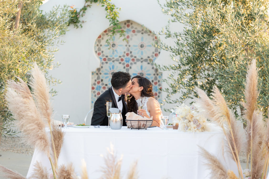 Malibu Estate Wedding couple kissing during dinner