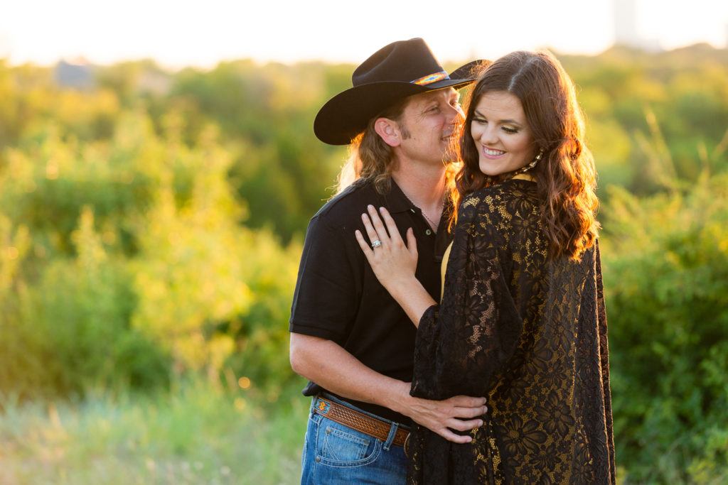 Cowboy smiling at fiancée during a Tandy Hills engagement session in Texas