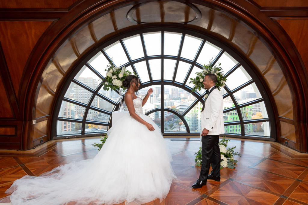 wedding first look with bride and groom in front of a huge window in a Dallas hotel for their wedding day with Dallas wedding photographers