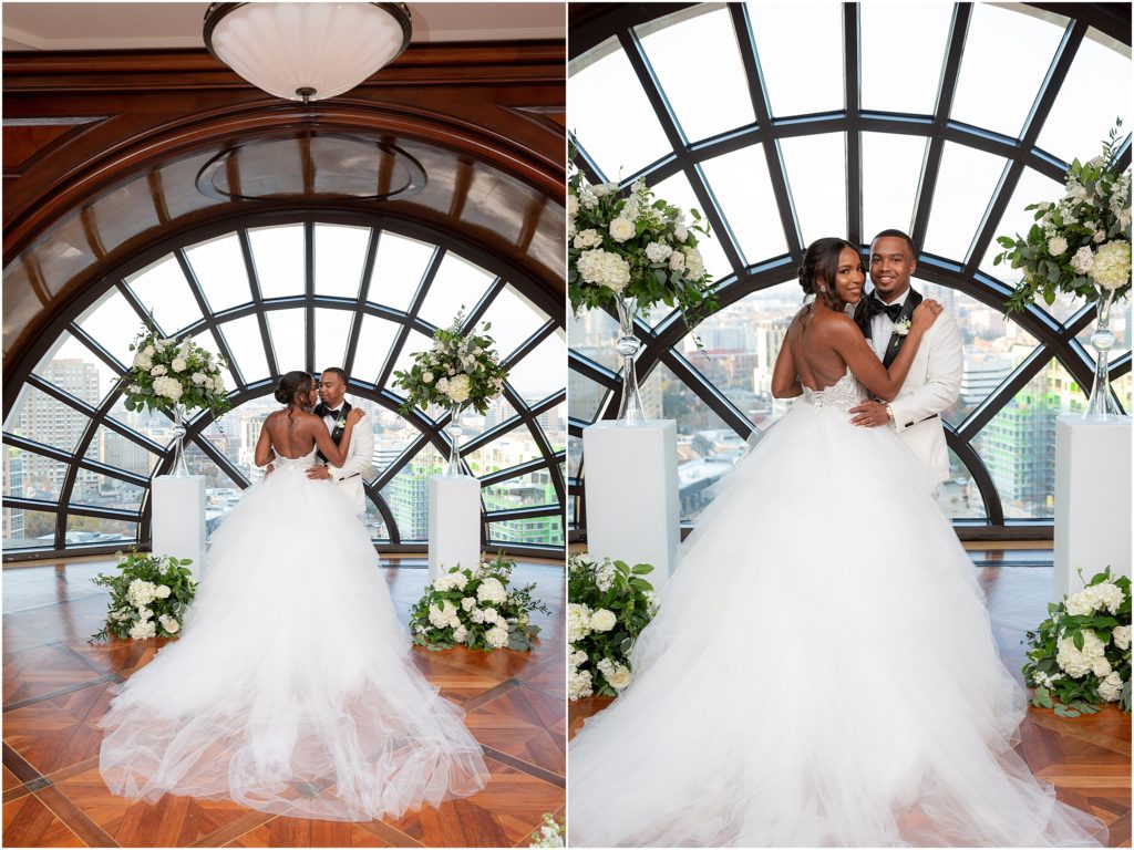 Dallas wedding photographers capture bride and groom standing together in their hotel wedding venue posing for their bridal portraits with white roses surrounding them
