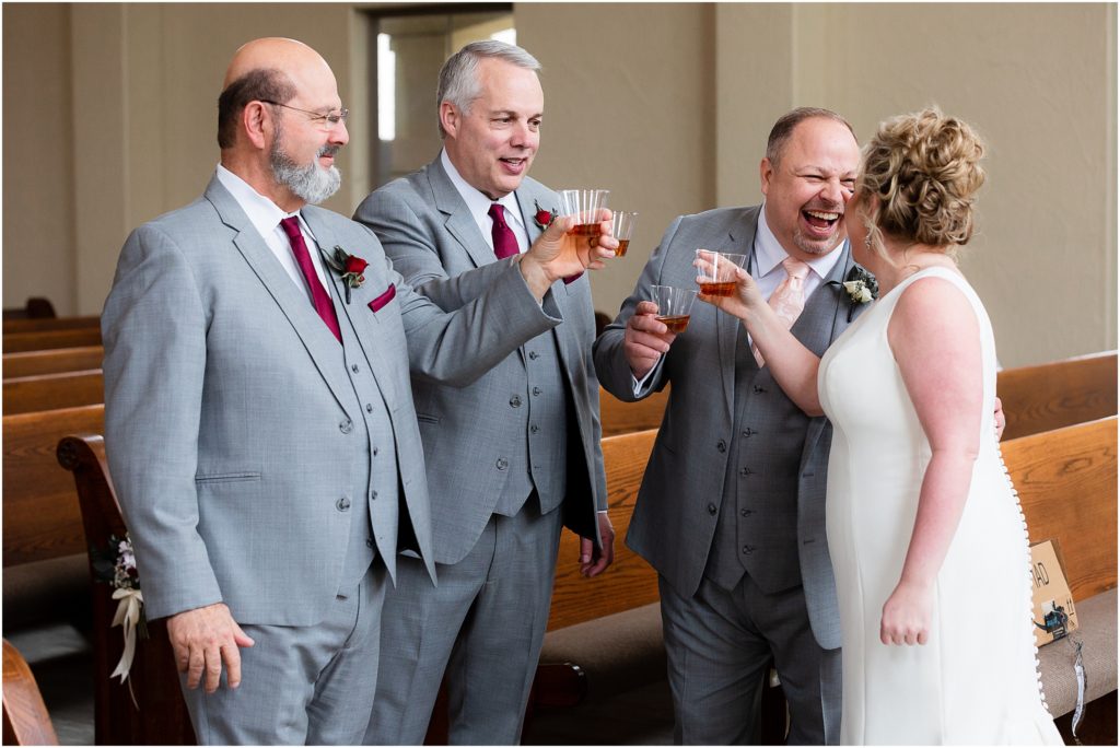 Two groomsmen, the groom, and the bride share a toast in the chapel of at Ana Villa wedding venue captured by Dallas wedding photographers