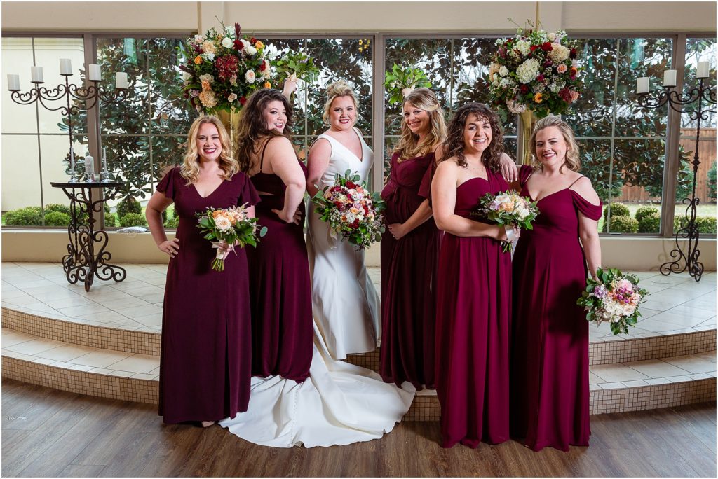 Dallas wedding photographers capture five bridesmaids posing with bride on the stairs of luxury wedding venue