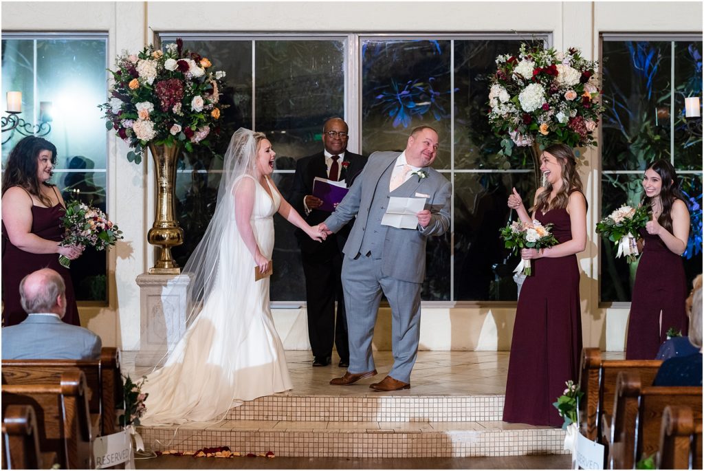 Groom leans over to daughter who gives a thumbs up during wedding ceremony captured by Dallas wedding photographers
