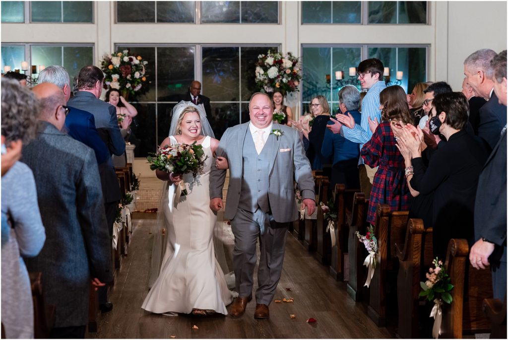 Bride and groom smile and walk up the aisle after wedding ceremony captured by Dallas wedding photographers