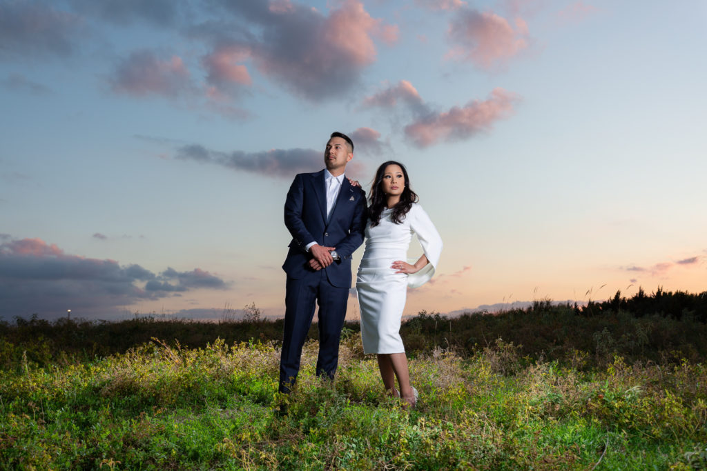 Engaged couple posing on top of hill with cotton candy sunset at Arbor Hills Nature Preserve in Dallas Texas for Dallas engagement session