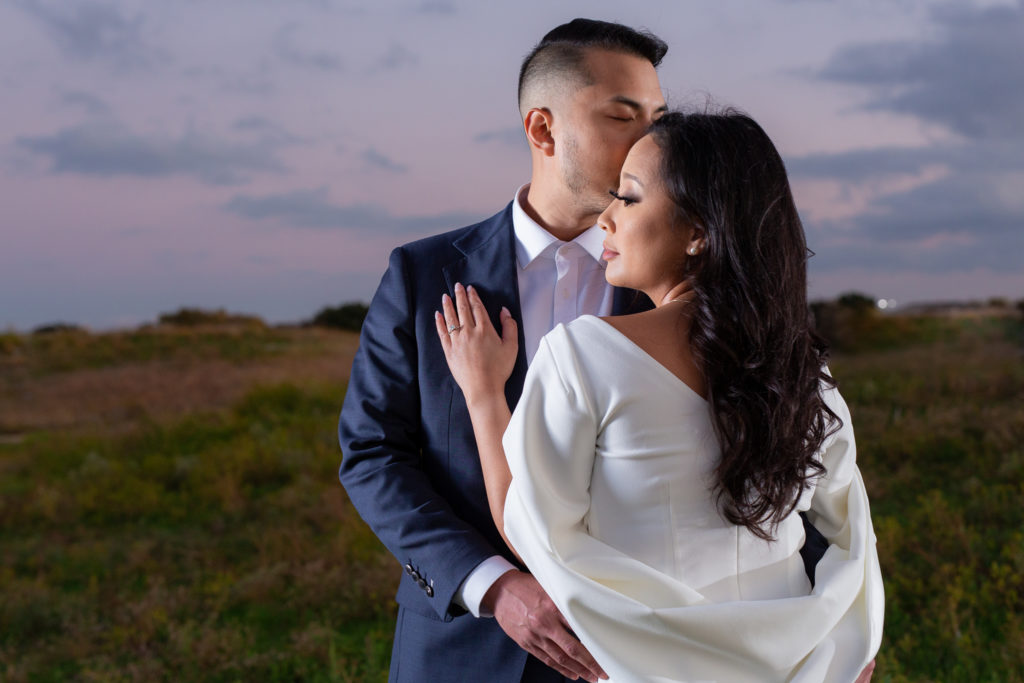 A Plano park engagement session with man embracing woman around the waist as she holds her hand to his chest