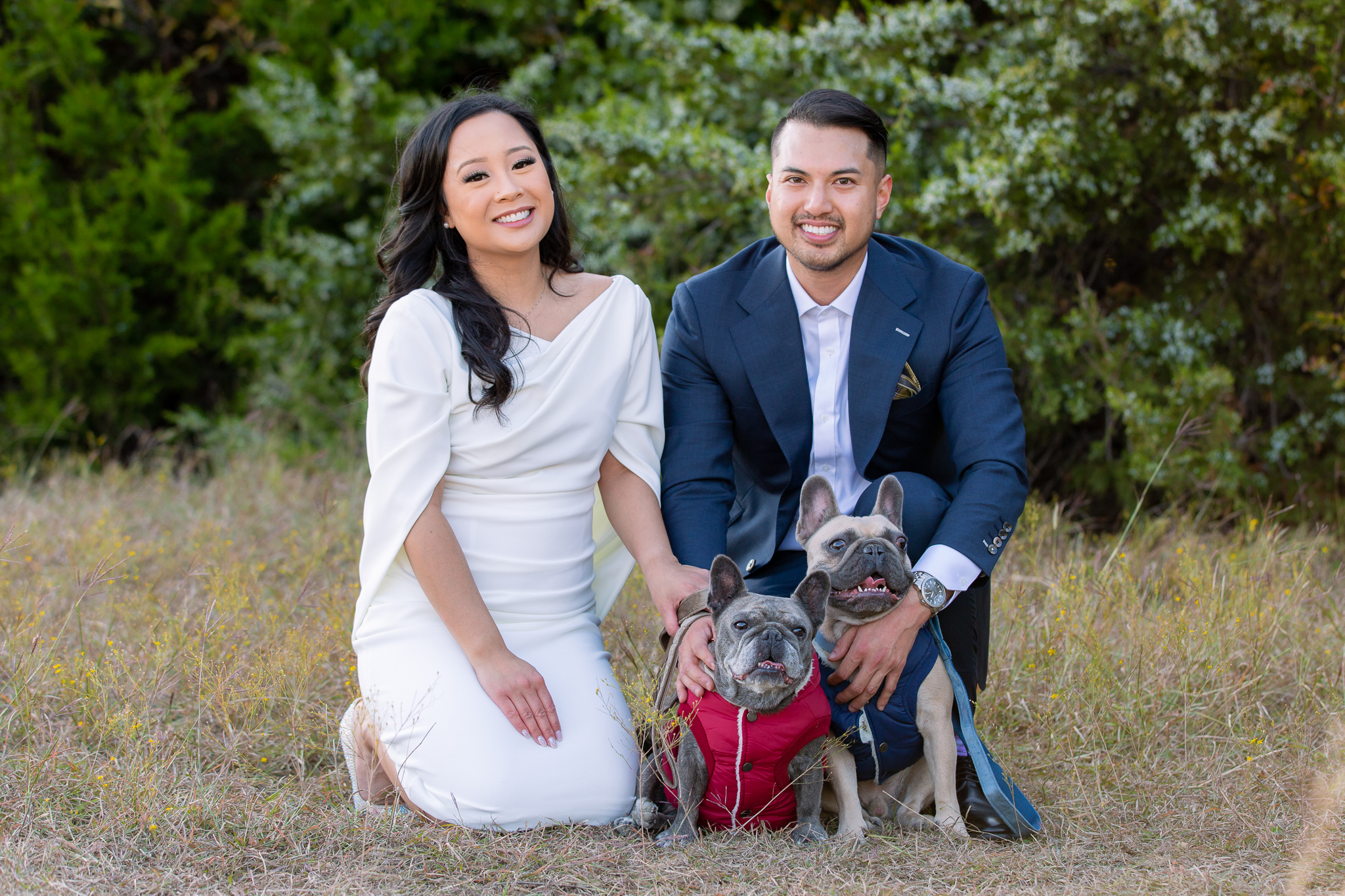 Bride and groom kneeling in Arbor Hills Nature Preserve with 2 pups during engagement session