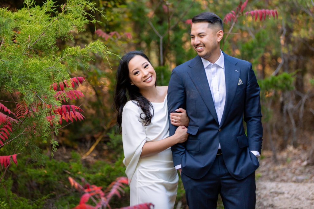 Engaged couple in red flowers at park  in Plano