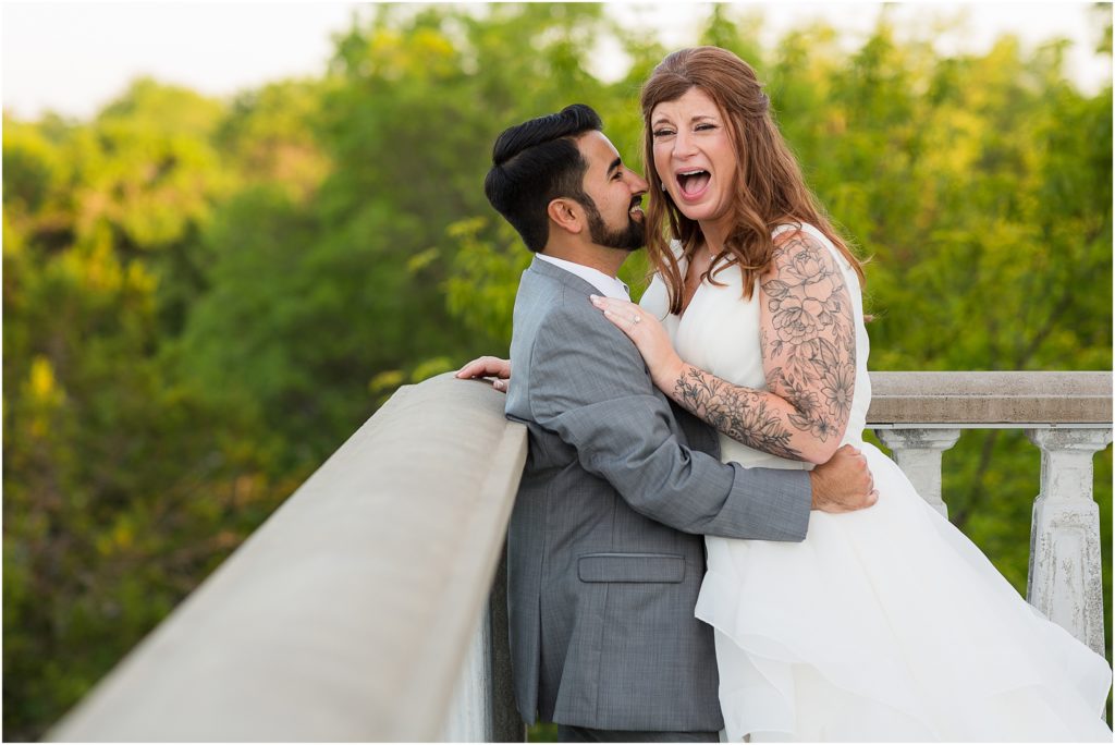 laughing bride with groom holding her outside their Dallas wedding venue