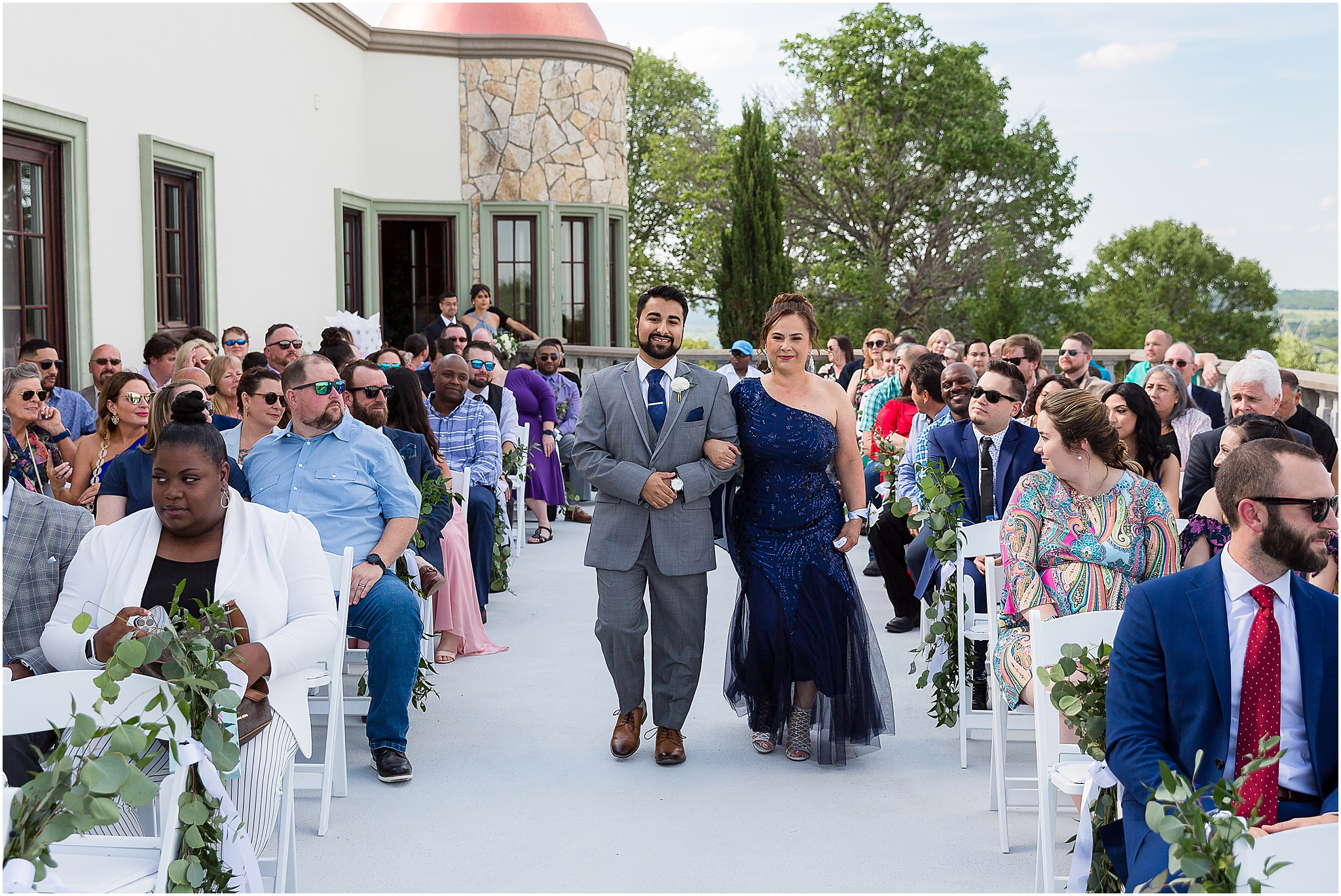 groom and mother of groom walking down aisle on balcony during stoney ridge villa wedding ceremony