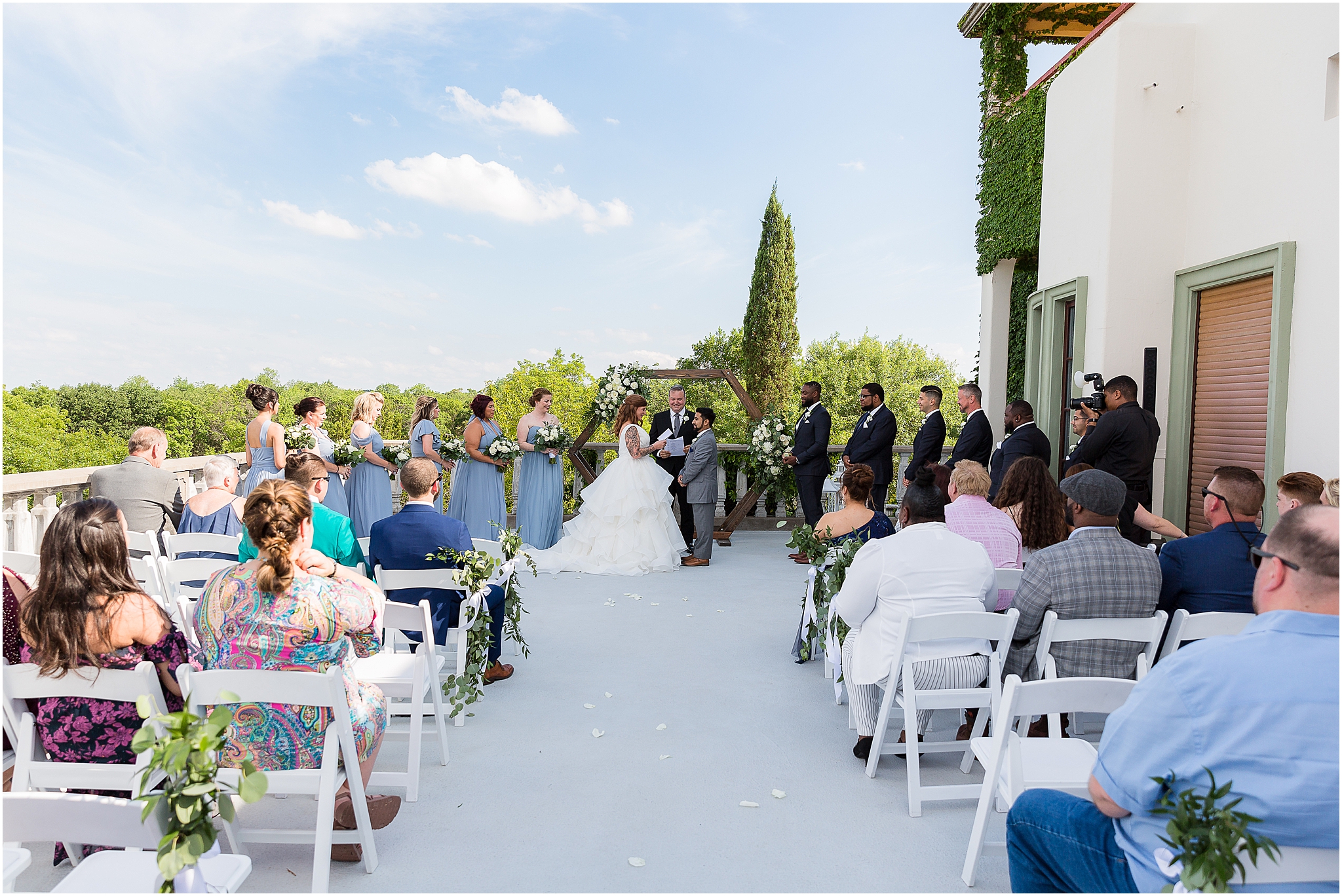 bride and groom standing with wedding party during balcony ceremony at stoney ridge villa in azle texas