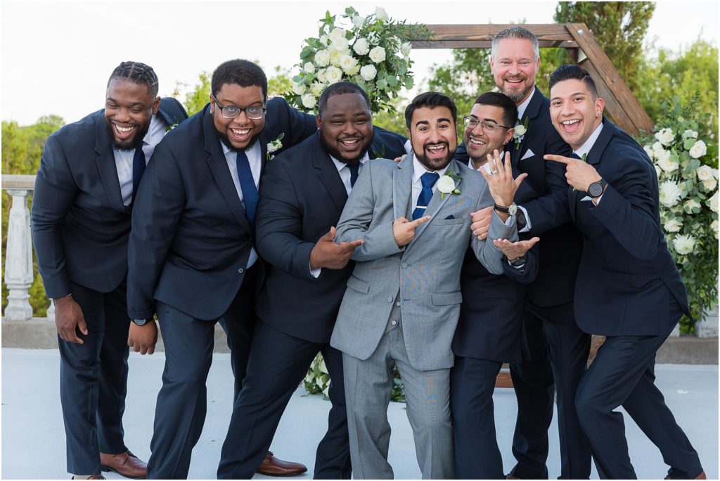 humorous groomsmen and groom photo showing wedding ring captured by Dallas wedding photographers