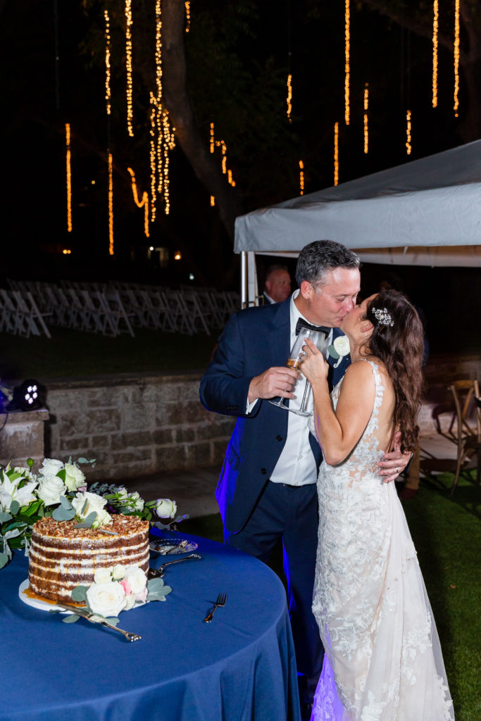 Dallas wedding photographer captures bride and groom kissing after their cake cutting at their Granbury wedding