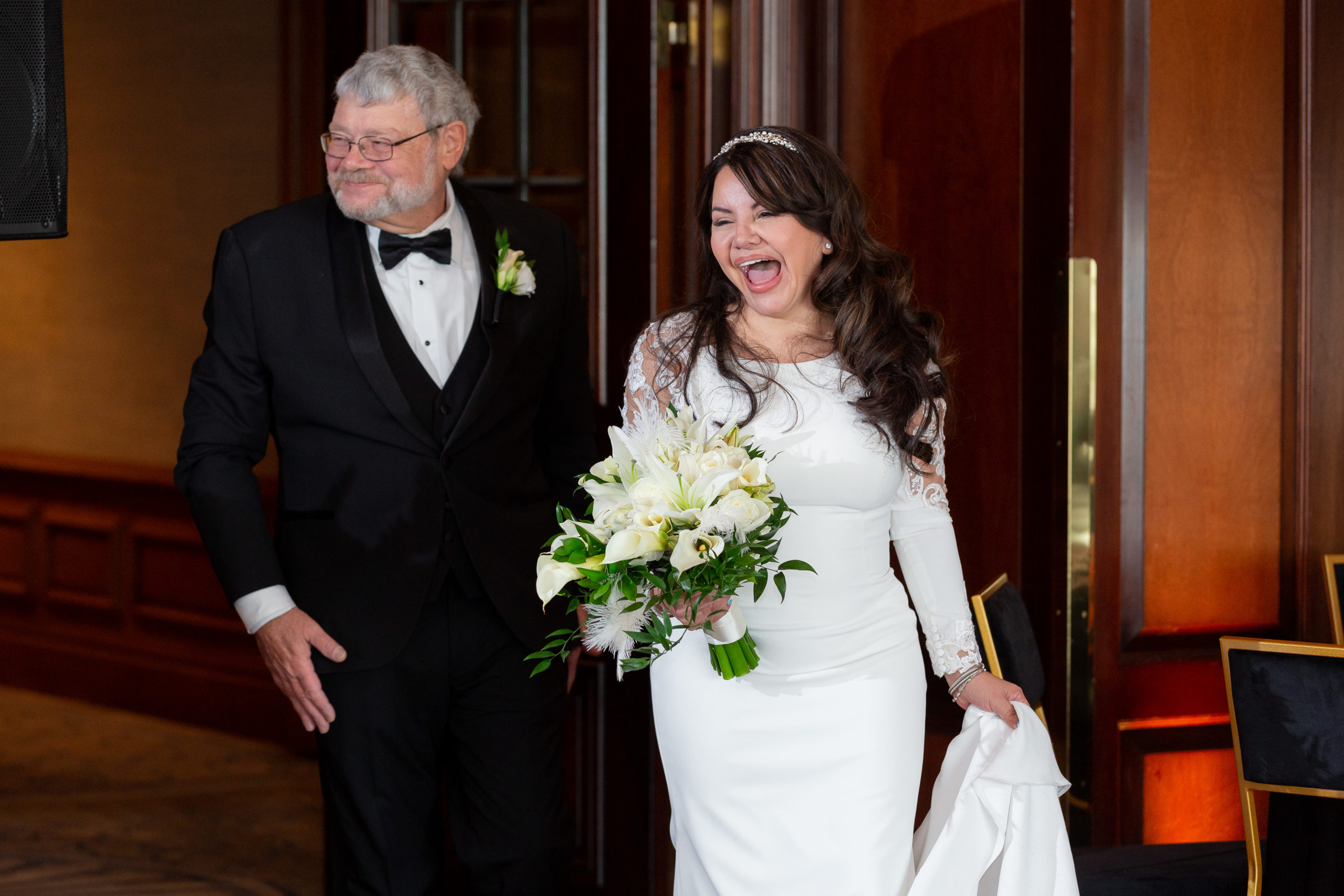bride and groom entering their wedding reception while laughing together and celebrating with their guests captured by Dallas wedding photographer