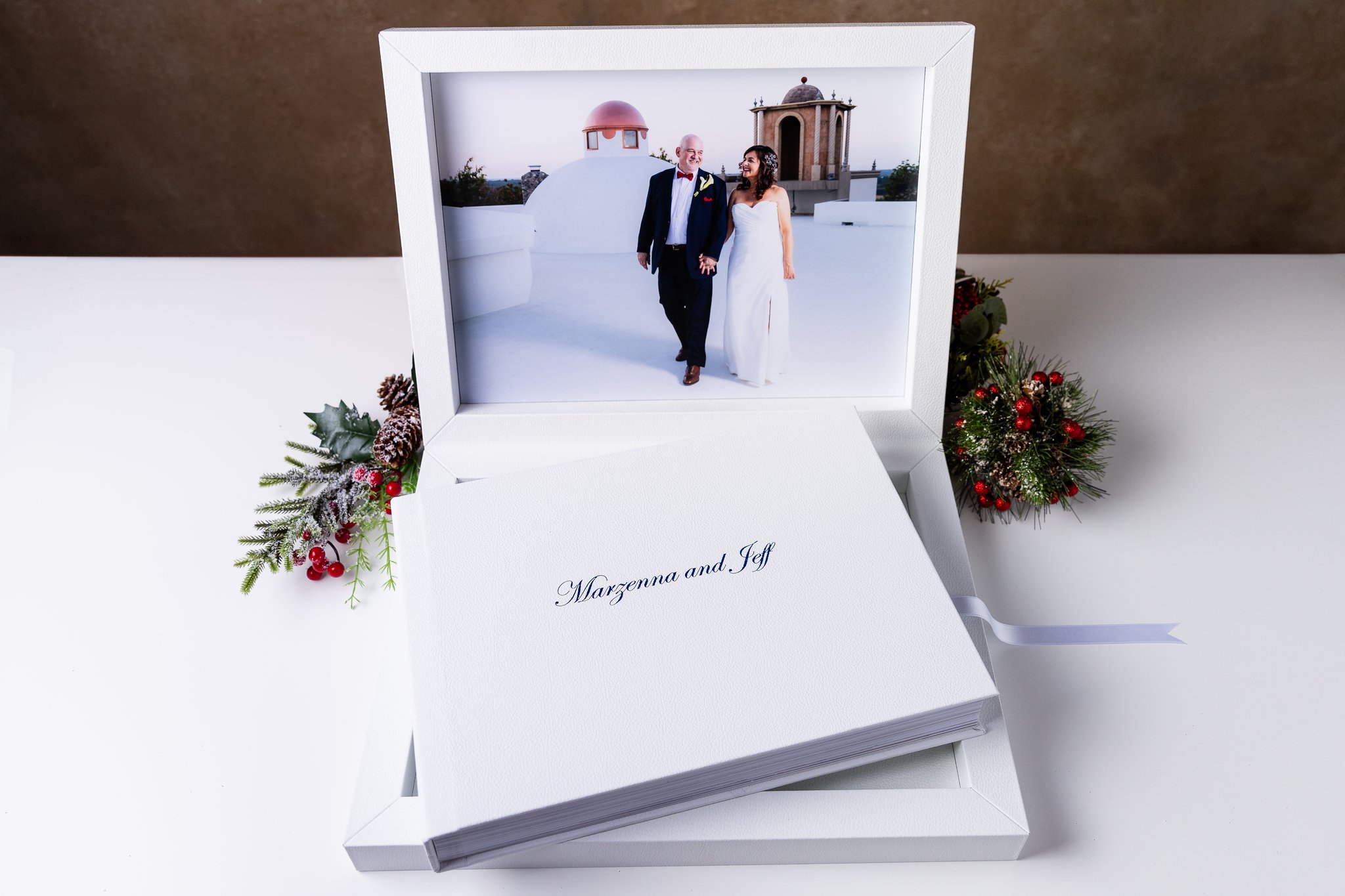 White leather luxury heirloom wedding album handcrafted in Italy by Stefani Ciotti Photography with image of bride and groom walking hand in hand on rooftop at Stoney Ridge Villa wedding venue