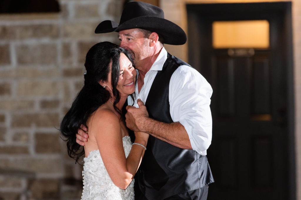 Dallas wedding photographer captures bride and groom dancing on the night of their wedding at their outdoor wedding venue