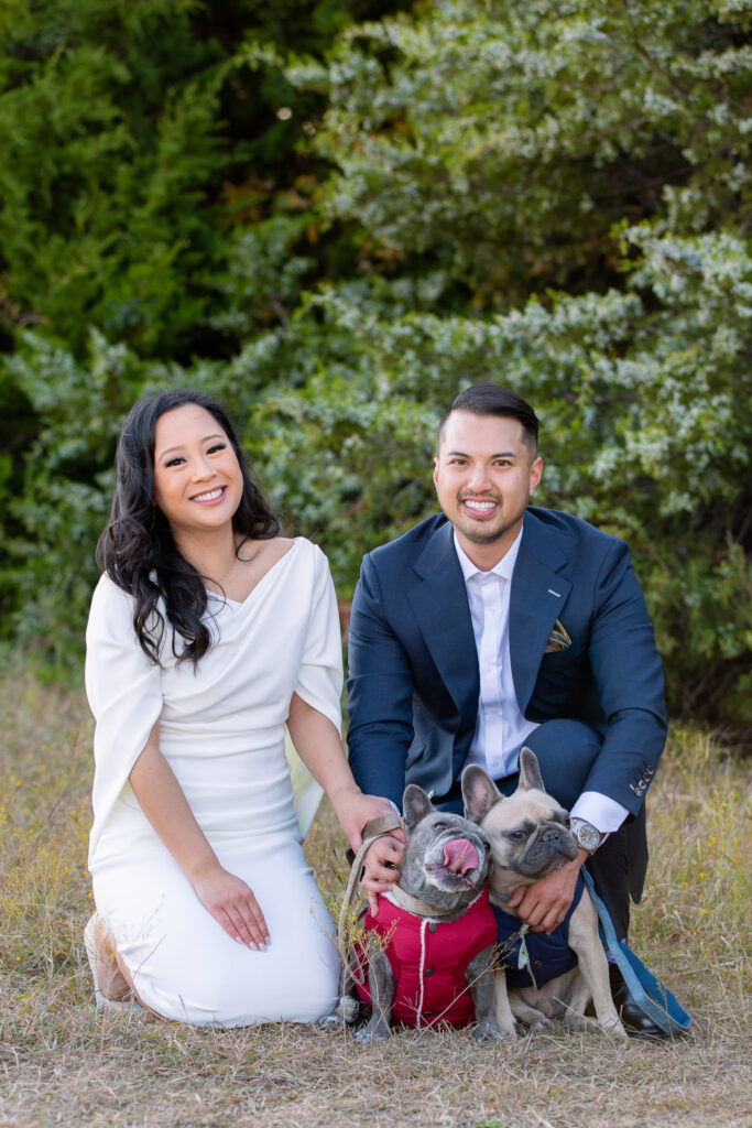 Couple Photos With Dogs making cute faces while engaged couple kneel down and smile