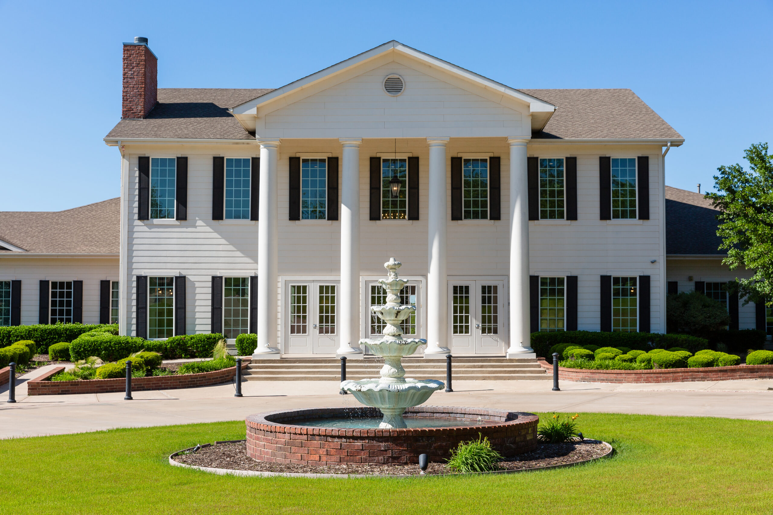 view of the the milestone denton from the front with a vintage style fountain and large white columns photographed by dallas wedding photographer