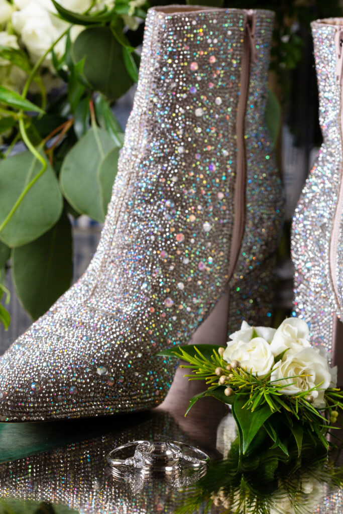 Bridal details showing off wedding rings, corsage and sparkly rhinestone boots