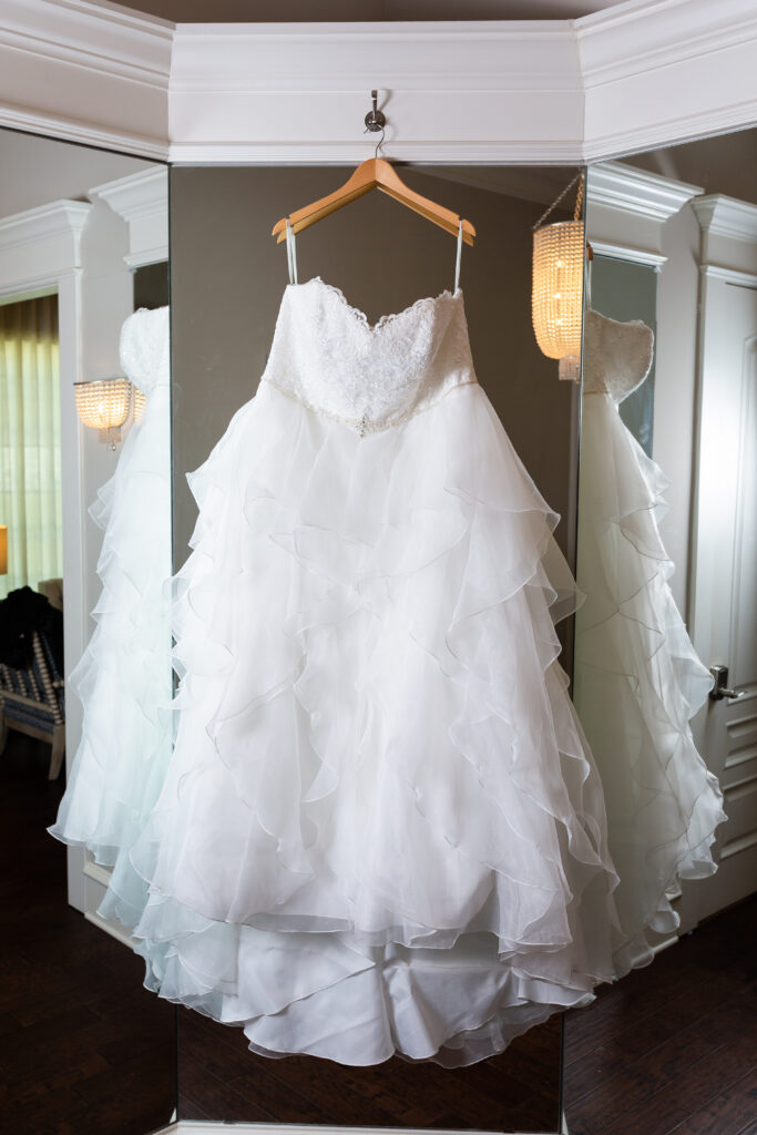 Wedding gown hanging against 3-paned mirror