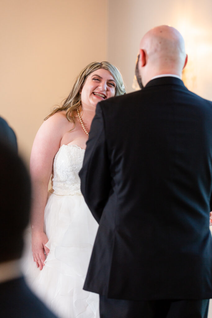 Dallas wedding photographers capture bride smiling at groom during wedding ceremony