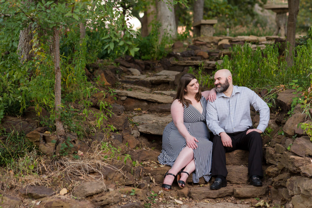 Dallas wedding photographer photographs engagement session at Texas Women's University with man and woman sitting together on a rock stair pathway