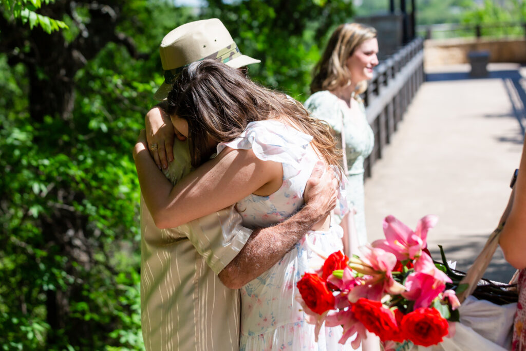 Dallas wedding photographers capture woman hugging man before proposal