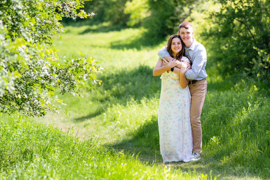 Dallas wedding photographers capture couple hugging in green field at Arbor Hills Nature Preserve