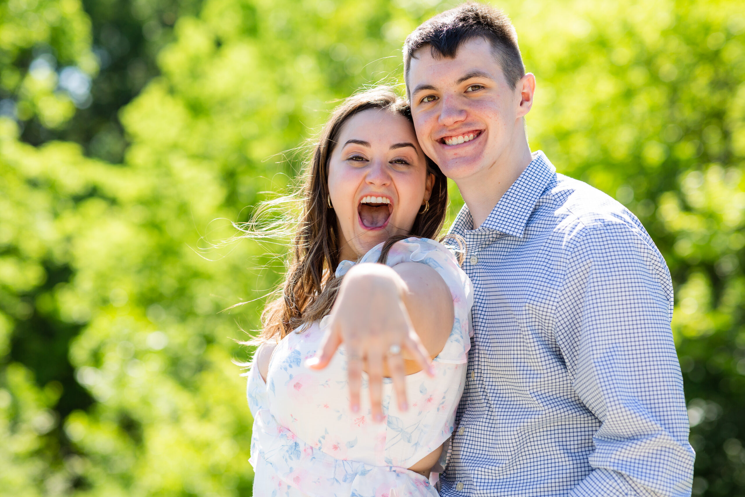 Engaged woman showing off engagement ring and smiling with new fiancé