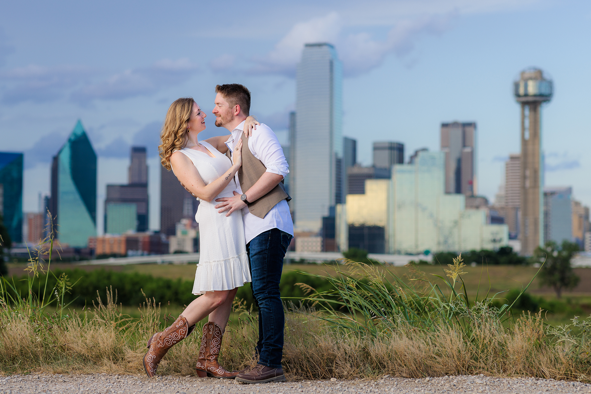 Dallas wedding photographer captures couple hugging and dipping while smiling at Trinity Overlook Park