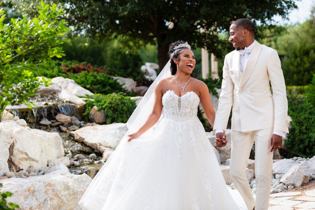 Dallas wedding photographers capture newly married couple walking together hand in hand at Knotting Hill Place