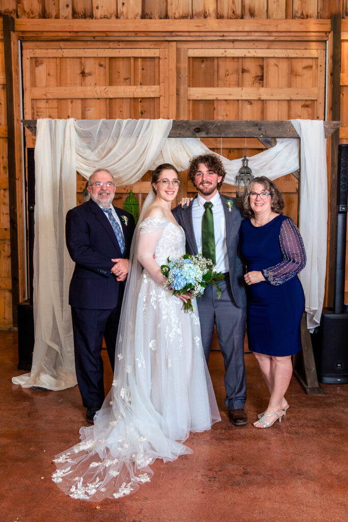 Dallas wedding photographers capture bride and groom standing with parents