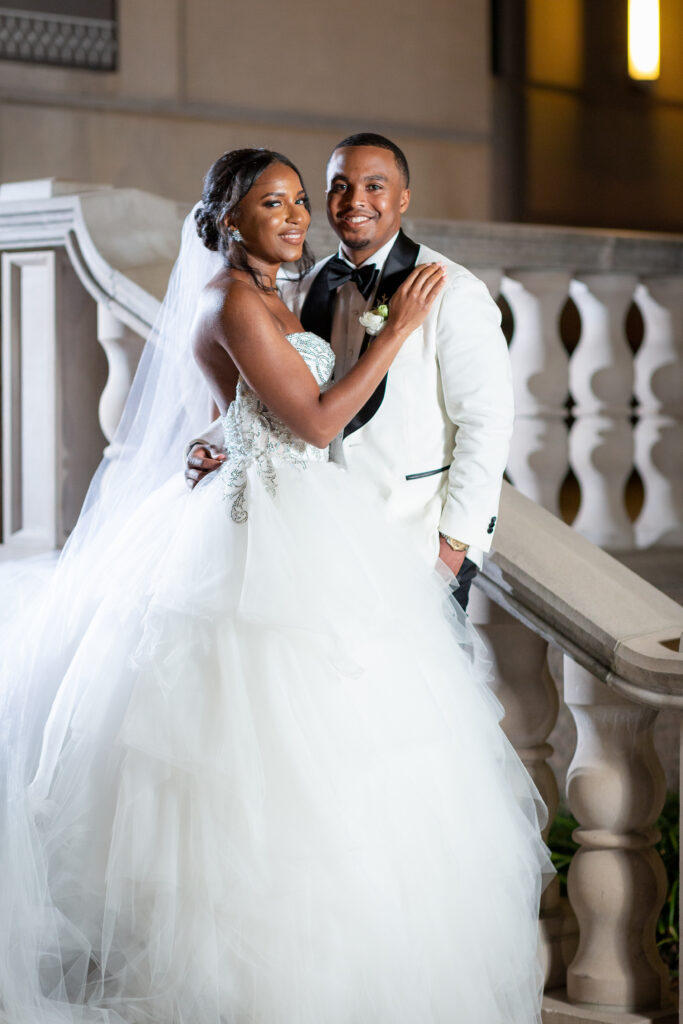 Couple standing on stairs in wedding attire at Hotel Crescent Court in Downtown Dallas