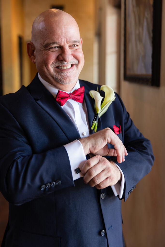 Dallas wedding photographer captures groom putting cufflinks on sleeves