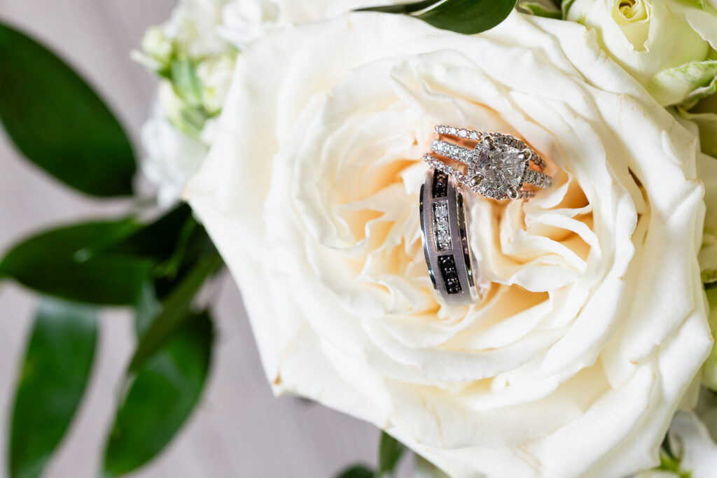 Square diamond halo engagement ring with custom band and black and platinum diamond wedding band in white rose