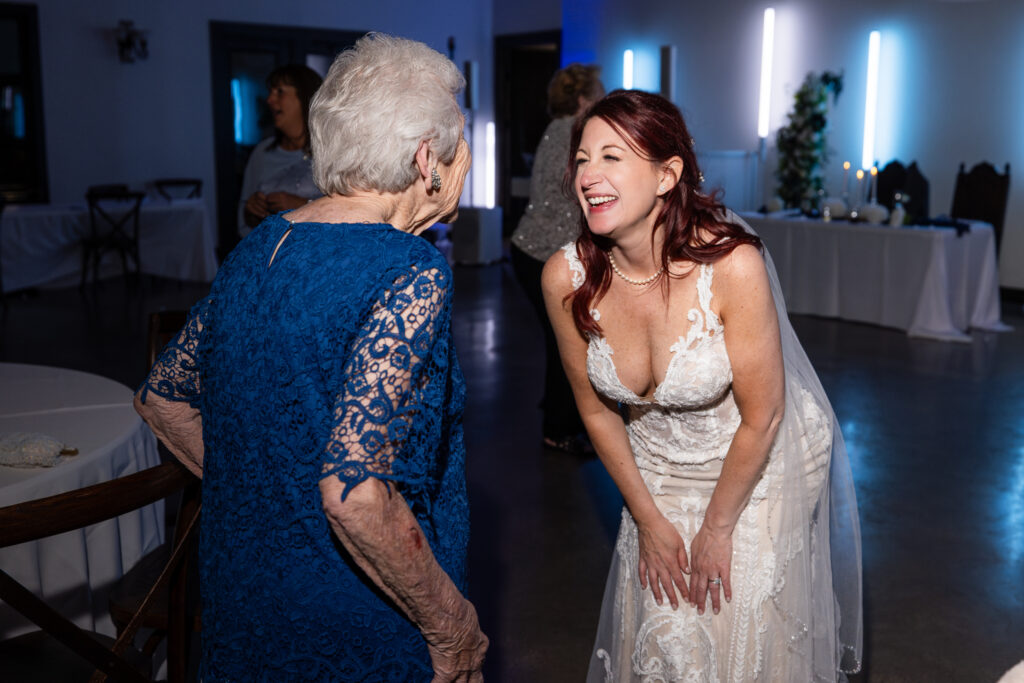 Bride laughing with grandma on dance floor