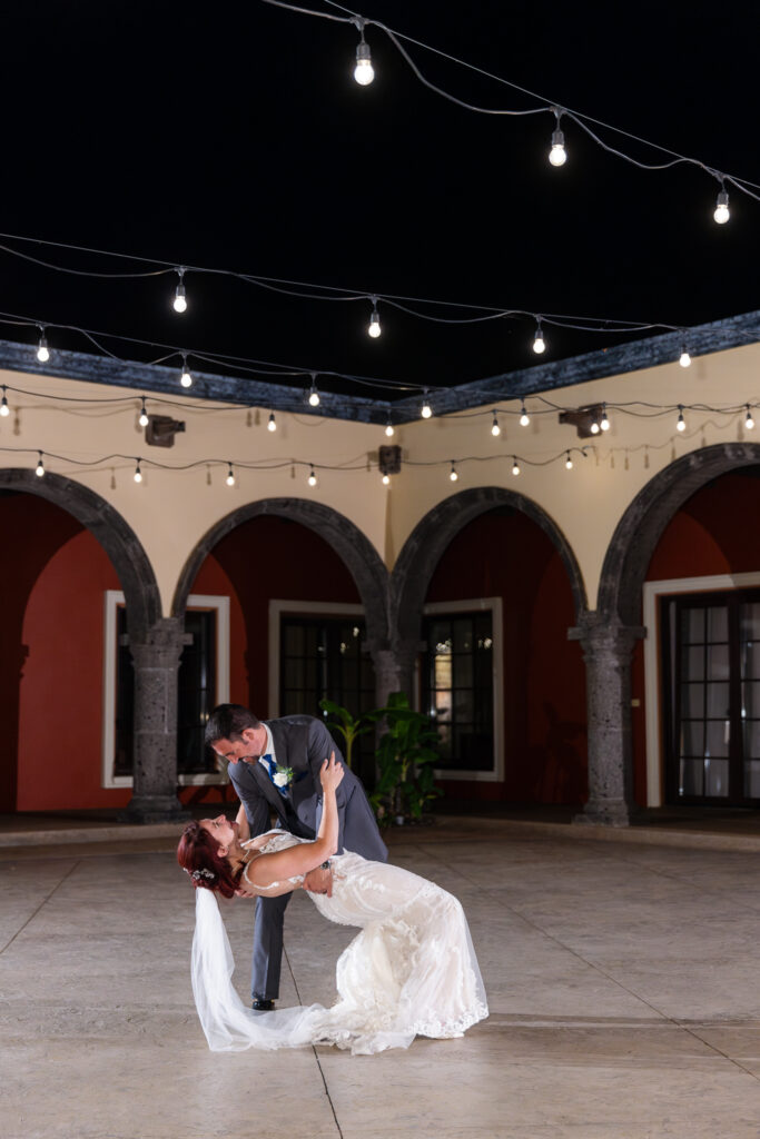 Bride and groom dipping during private last dance in courtyard of Azle TX wedding villa