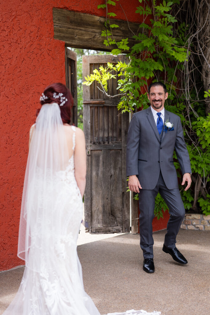 Groom turning around with a big smile to see bride during the first look