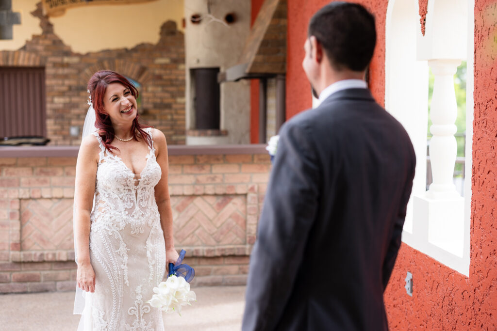 Bride smiling big at groom during first look