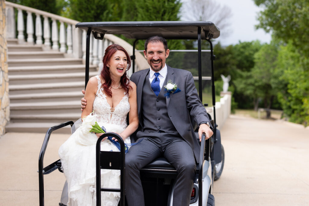 Bride and groom laughing on the back of a golf cart