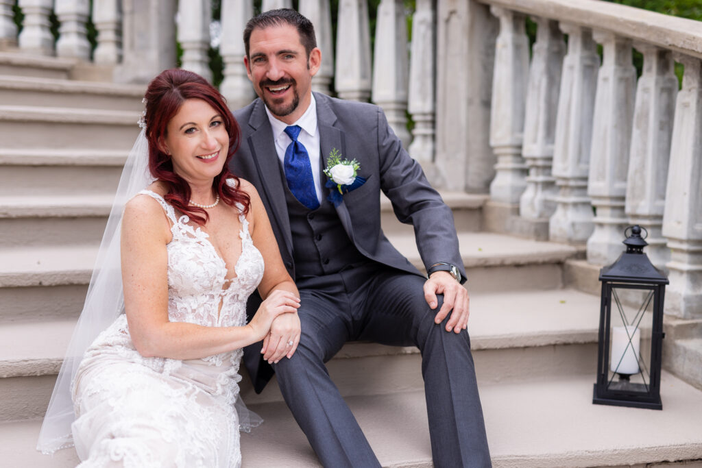 Bride and groom sitting and laughing on grand staircase at Stoney Ridge Villa in Azle TX