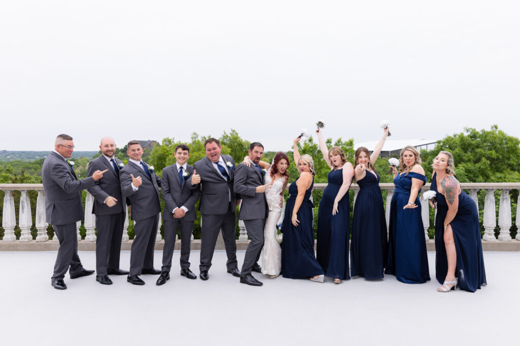 Excited wedding party in grey suits and blue dresses