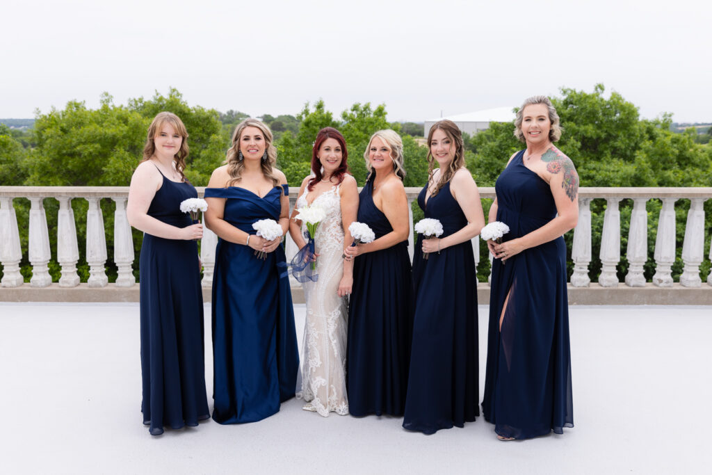 Bride and bridesmaids in blue dresses smiling at camera