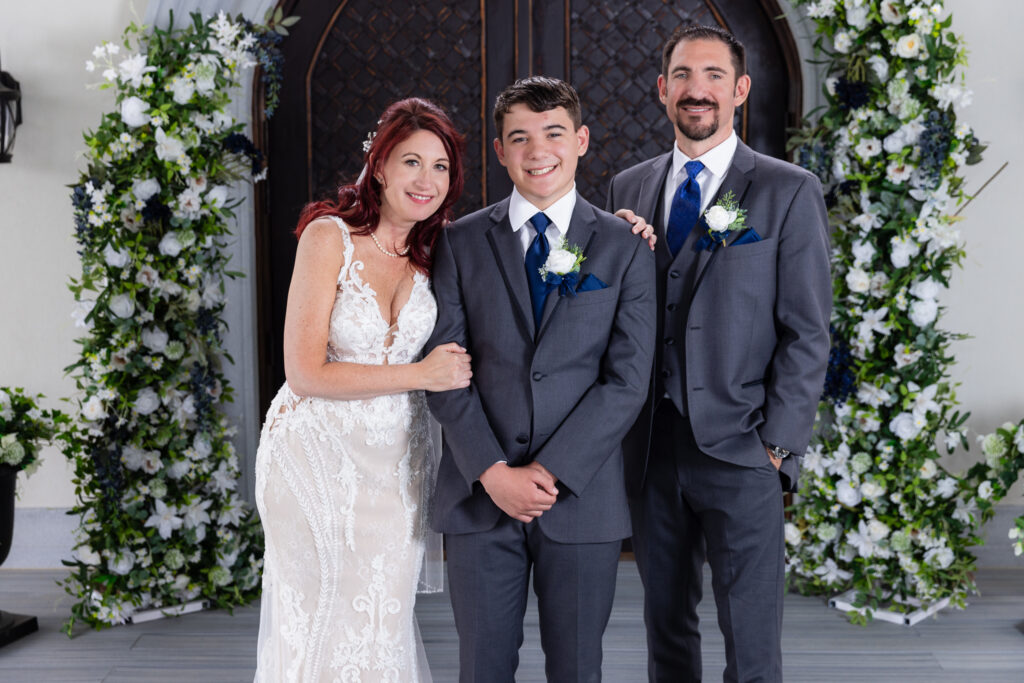 Bride and groom smiling with son at ceremony site at Stoney Ridge Villa covered ceremony space