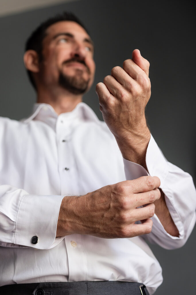 Groom putting on cufflinks