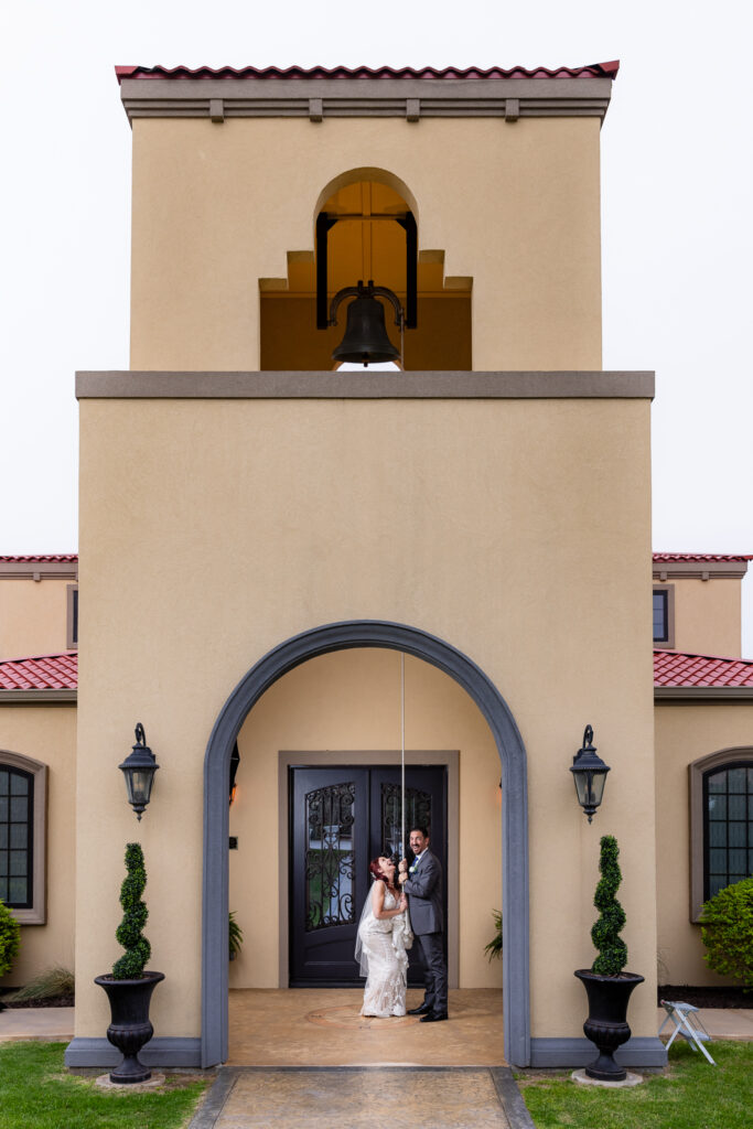 Bride and groom pulling rope to bell tower at Azle TX wedding venue Stoney Ridge Villa