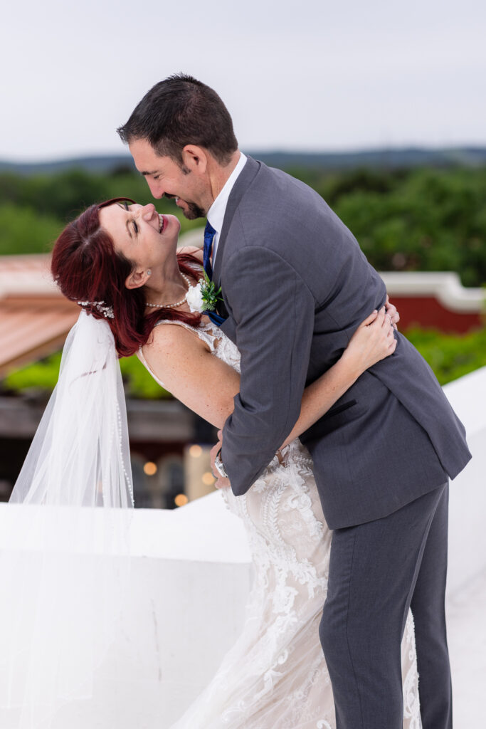 Bride and groom laughing at each other on rooftop of Azle TX wedding venue