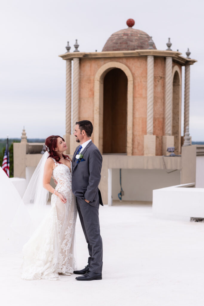 Bride and groom dancing on wedding venue rooftop near bell tower