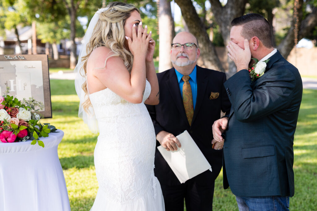 Bride and groom wiping tears from eyes during intimate elopement wedding ceremony